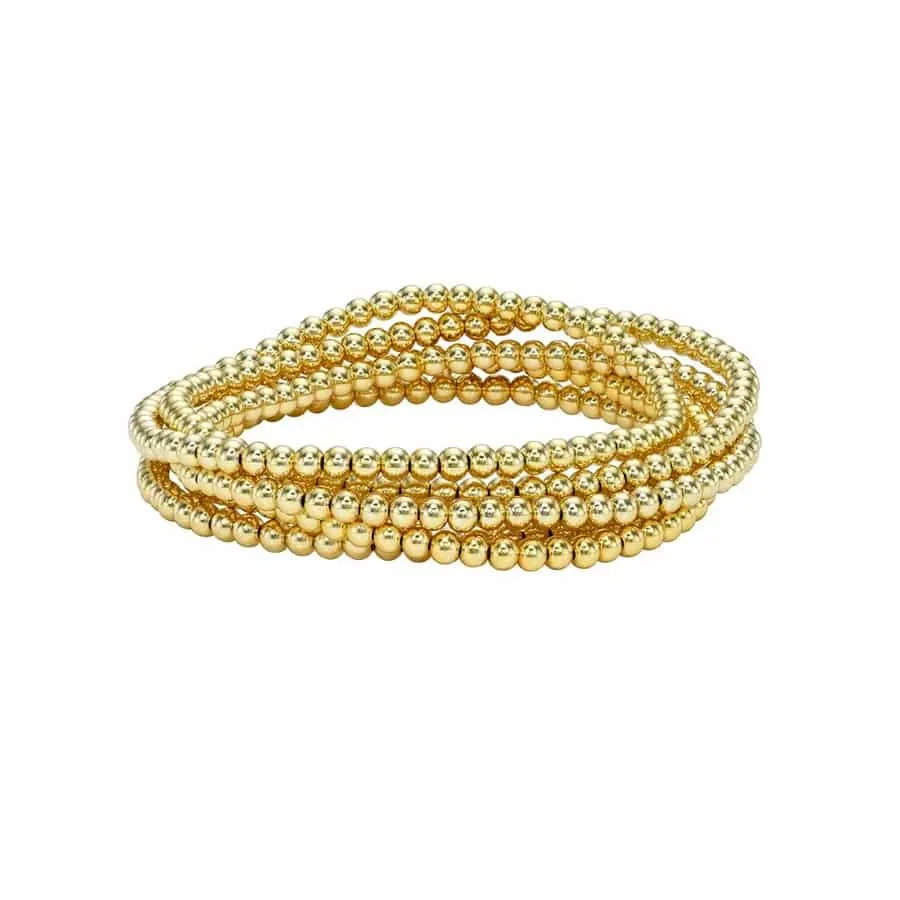 Stack of Zoe Lev gold bead bracelets