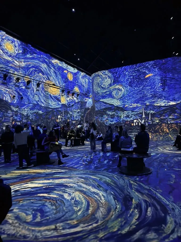 Van Gogh Starry Night projections swirling across the walls and floor at Fabrique des Lumieres