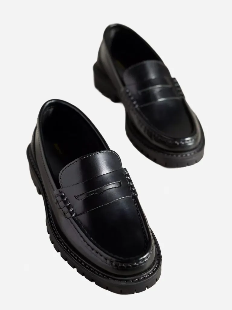 Pair of black leather penny loafers with chunky lug soles