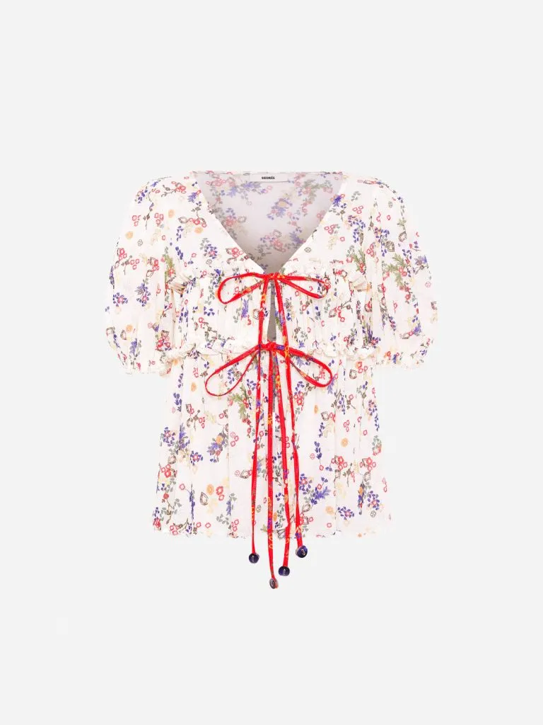Siedrés Emma Top, a white floral mesh blouse with red front ties and puff sleeves